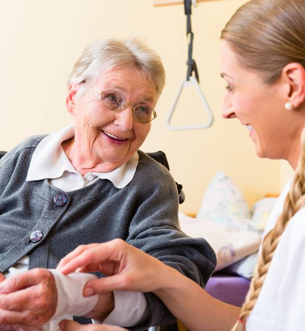 Elderly woman receiving care from nurse.